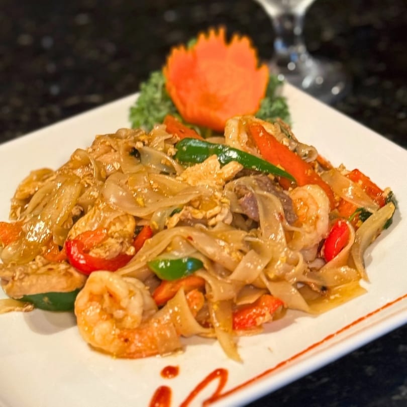 Jutamas Thai Restaurant's Pad See Ew with shrimp, chicken, and colorful vegetables on a white plate.
